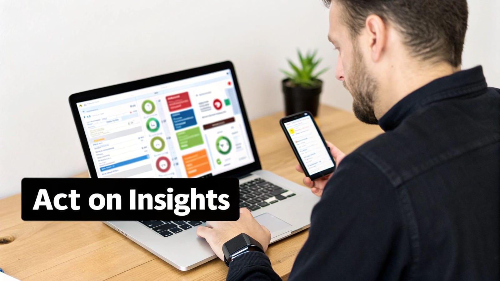 A man reviews insights on his smartphone, with a laptop displaying a business dashboard in the background.